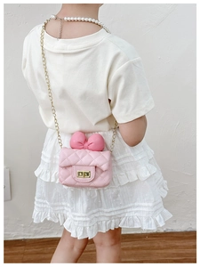 Detailed view of pink quilted crossbody bag for girls with sweet bow and gold chain strap