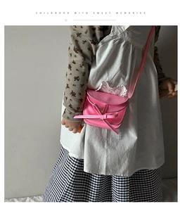 Sweet pink girls crossbody bag featuring a large decorative bow and thin strap detail