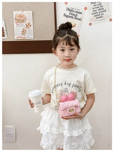 Close-up of pink quilted crossbody bag for girls with large bow and gold chain strap