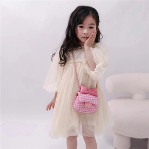 Pink tweed crossbody mini bag with bow and chain strap on a white dress for girls