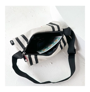 Detail view of the canvas crossbody bag interior with striped pattern and zipper closure