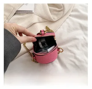 Macro detail of the pink round mini bag showing interior storage and gold chain strap