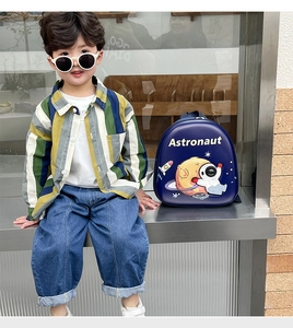 Detail of blue hardshell astronaut backpack for kids featuring cartoon space graphics