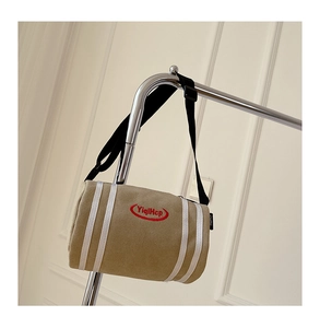 Detail of khaki canvas bucket bag with sports stripes and red embroidered logo