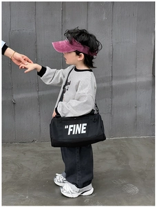 Kids black cylinder canvas crossbody bag with white FINE letter print on striped shirt