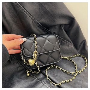 Close-up of black quilted crossbody bag with gold chain and adjustable metal ball