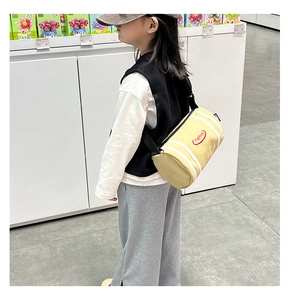 Close-up of a yellow striped cylinder crossbody bag for kids with adjustable strap