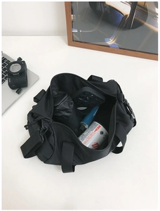 Detail showing the large interior capacity of the black cylinder kids canvas crossbody bag