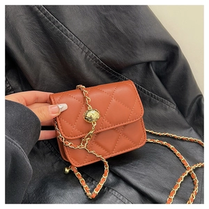 Detail of quilted mini crossbody bag with golden ball chain adjuster in brick red finish