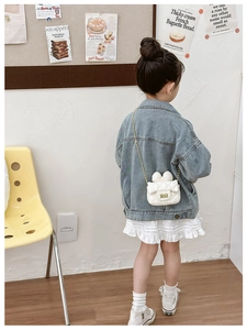 Detailed view of white quilted crossbody bag for girls with bow decor and gold chain