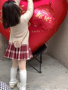 Pink round mini crossbody bag for kids styled with casual outfit and heart balloons