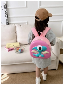 Detail view of the pink 3D cartoon dinosaur eggshell backpack with wide shoulder straps