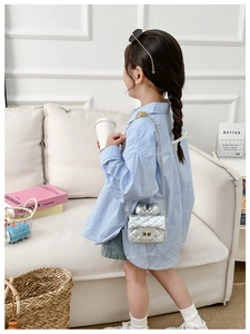 Girl's silver quilted crossbody bag with a large bow detail and gold chain strap