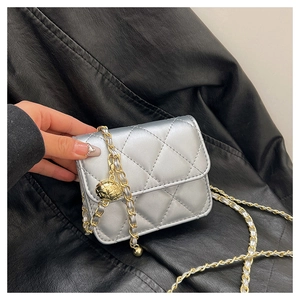 Detail of silver quilted mini crossbody bag with gold ball charm and chain strap