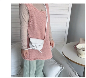 Mini white leather crossbody bag for kids featuring a cute bow tie and shoulder strap