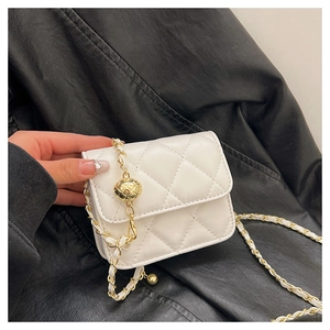 Detail of white quilted mini crossbody bag with golden chain and ball ornament