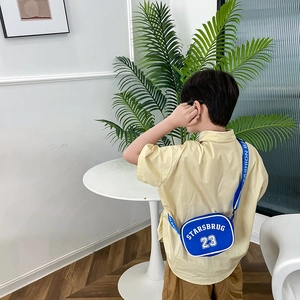 Blue nylon kids crossbody bag with letter print shown in a lifestyle home setting