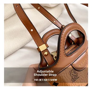 Detail view of adjustable shoulder strap and textured brown faux leather material
