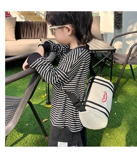 Close-up of kids white striped bucket bag featuring red logo and adjustable shoulder strap