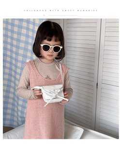Detail of white PU leather mini crossbody bag with bow decoration on a child model