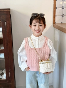 Mini sac à bandoulière matelassé blanc avec chaîne en métal porté par une fille en tenue chic