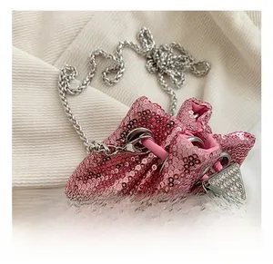 Détail du sac seau à paillettes roses avec chaîne argentée et boucle triangle en strass