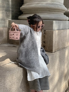 Pink mini bear pattern crossbody bag for girls shown with a grey knit cardigan in natural light