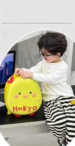Toddler showing a yellow bird hardshell backpack with cute 3D character features
