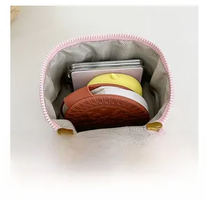 Vue détaillée de l'intérieur du sac seau rose matelassé avec doublure et zip doré