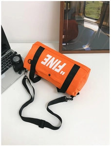 Detail of orange cylindrical canvas crossbody bag for kids with FINE print and nylon straps