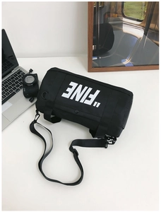Detail of black cylindrical nylon crossbody bag with FINE print and adjustable strap