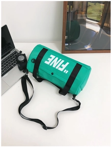 Close-up of vibrant green cylindrical kids canvas bag with white FINE letter print