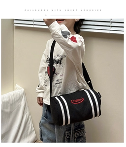 Detail of kids black bucket crossbody bag with white stripes and adjustable strap
