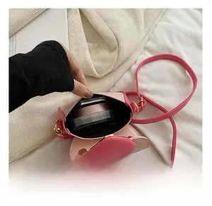 Detail showing the internal capacity of the pink mini crossbody bag with a magnetic closure