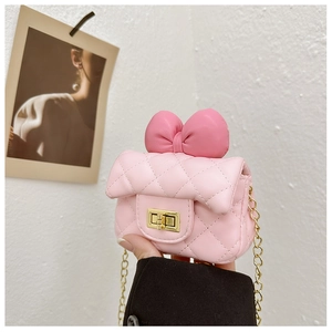 Detailed view of pink quilted handbag with large bow and golden metal twist lock