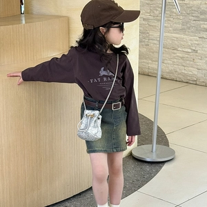 Sac seau argenté à paillettes associé à un t-shirt marron et une jupe en jean pour enfant