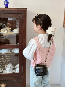 Détail du sac seau noir matelassé avec bandoulière en chaîne et double fermeture éclair