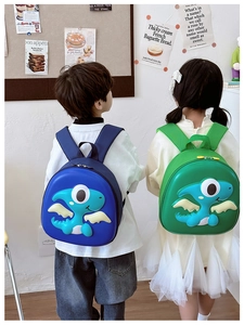 Detail view of colorful 3D dinosaur hardshell backpacks for kids in blue and green colors