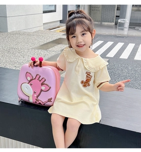 Close-up of pink hardshell kid backpack featuring a cute cartoon giraffe and plush charm