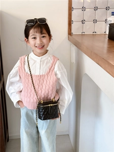 Détail d'un mini sac seau matelassé noir avec bandoulière chaîne sur un mannequin enfant