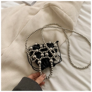 Dettaglio di mini borsa a mano con perle argentate e sacchetto interno nero a coulisse