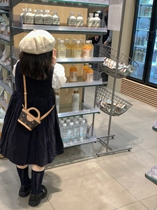 Mini brown monogram crossbody bag with round handle on a young girl in a shop