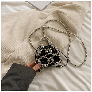 Dettaglio mini borsa nera a secchiello con rete di perle d'argento e catena