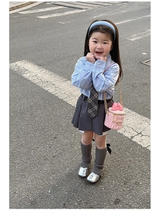 Photo de mode d'un sac seau rose matelassé avec une tenue de style écolière pour fille