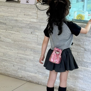 Détail d'un sac seau rose à paillettes avec cordon de serrage et bandoulière chaîne