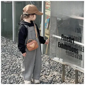 Brown PU leather heart crossbody bag for kids styled with denim overalls and black hoodie