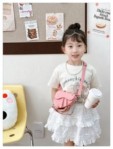 Gros plan du mini sac selle rose avec bandoulière cuir et poignée chaîne pour fille