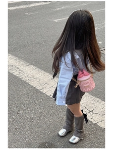Vue détaillée du sac seau rose pour filles avec nœud 3D et motif de cœur dans la rue