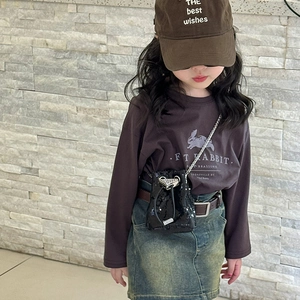 Gros plan d'un sac seau noir à paillettes pour enfant avec bandoulière en chaîne et cordon