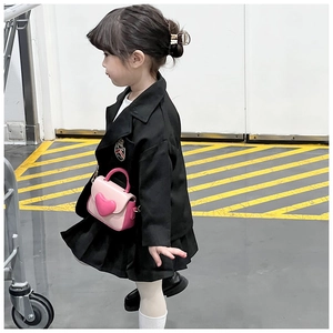 Detail of pink heart-shaped crossbody bag paired with a black girl's school suit
